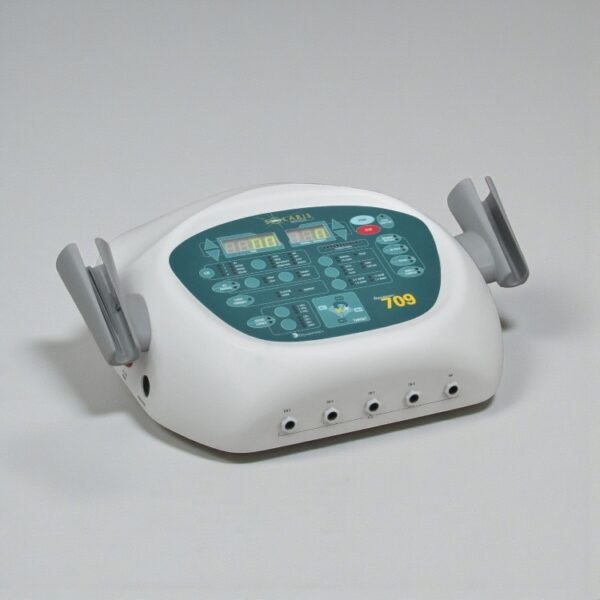 Angled view of a white Dynatron Solaris 709 combination therapy device featuring a teal control panel, digital LED displays, front output jacks, and two grey side holsters for probes.
