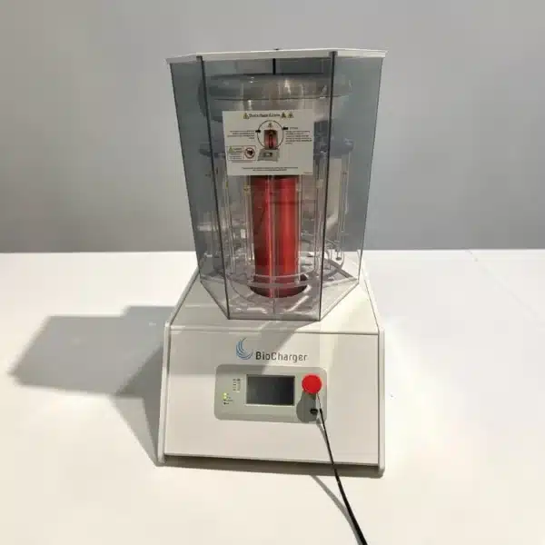 BioCharger NG professional wellness platform device on white table, showing hexagonal glass tower and control panel with emergency stop button.